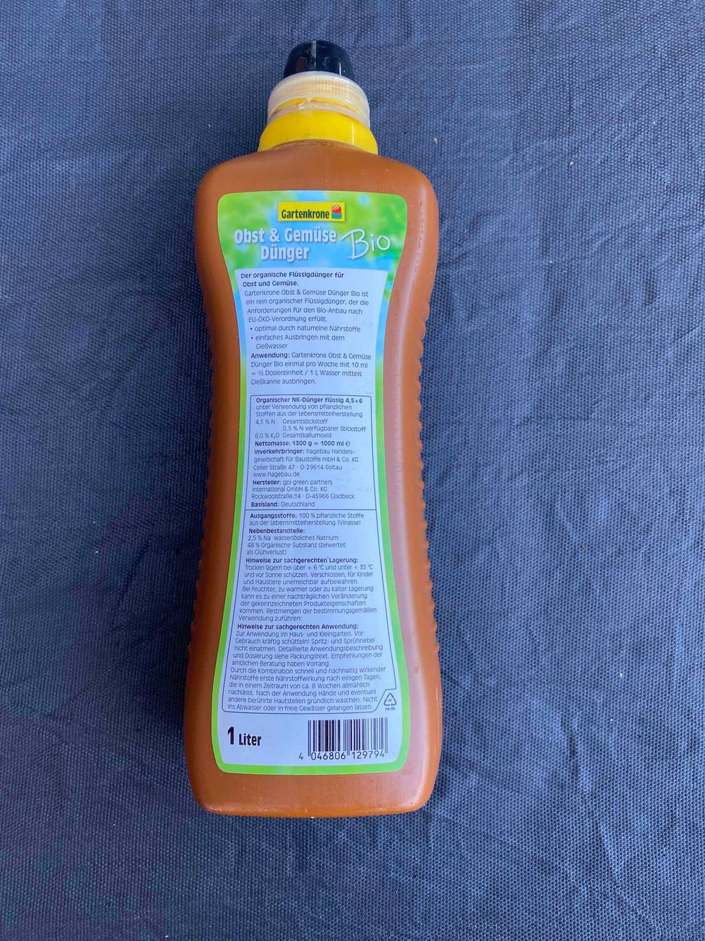 Im Test: Rückseite einer Flasche des Gemüsedüngers auf einer blauen Fläche liegend.
