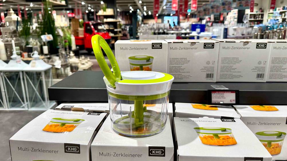 Ein getesteter Gemüsezerkleinerer von der Seite auf mehreren Originalkartons in einem Verkaufsladen st4ehend.