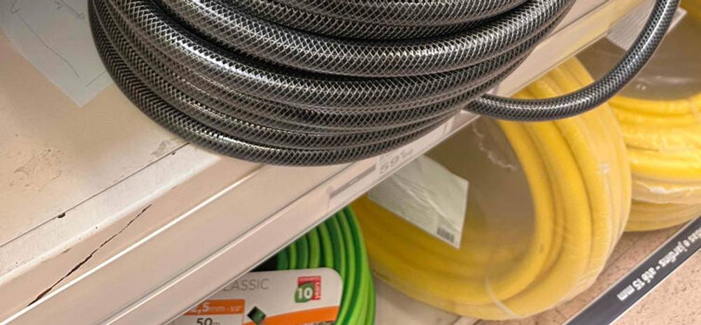 Im Test: Gartenschläuche in 3/4 Zoll, mit 50 Metern Länge liegen in einem Verkaufsregal.