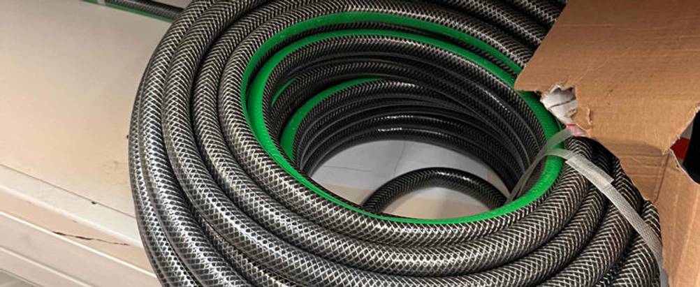 Nahaufnahme eines schwarz-grünen verstärkten 3/4-Zoll-Gartenschlauchs im Test.