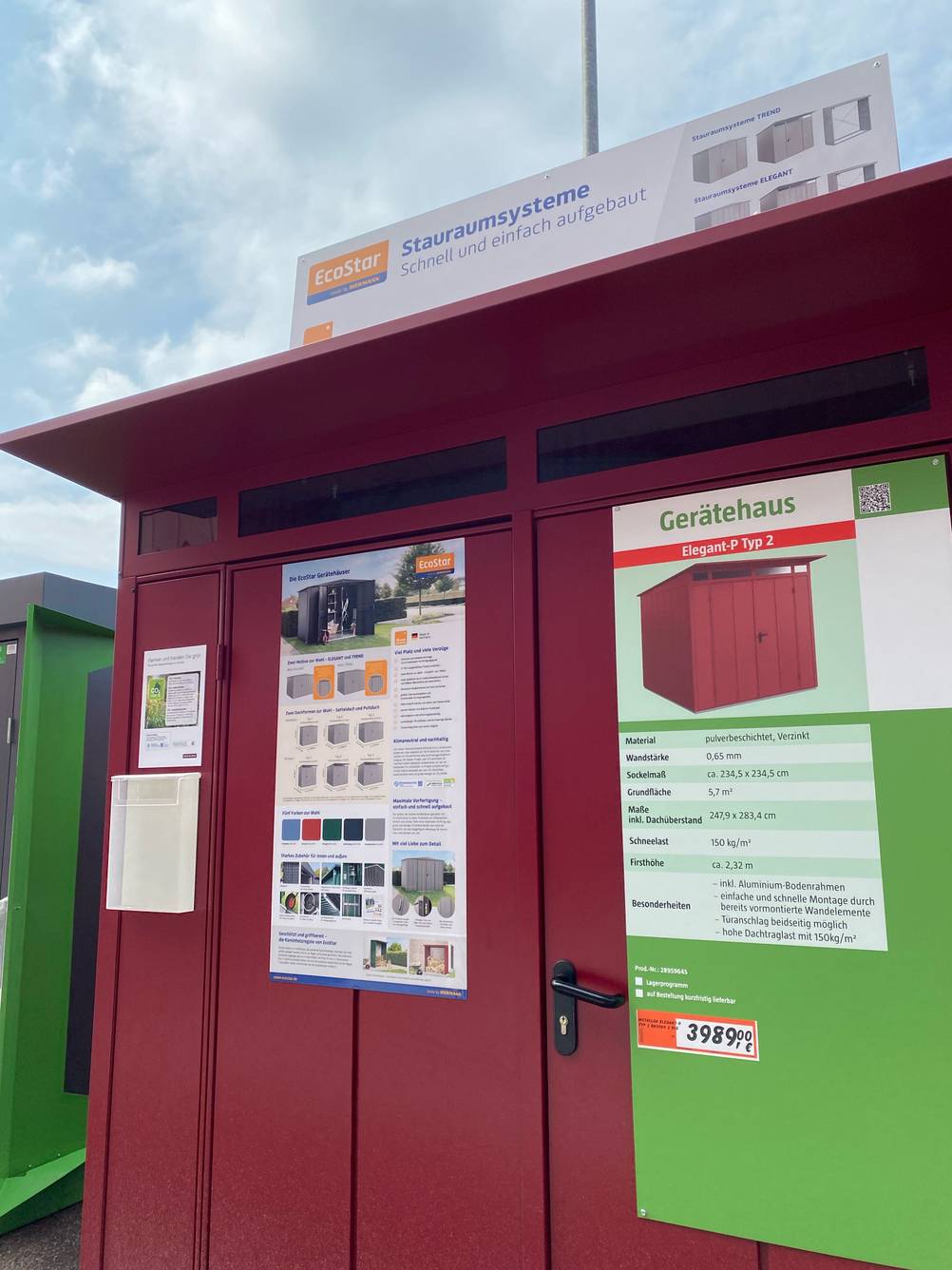 Gerätehaus aus Metall getestet: Das Haus von schräg vorne mit angebrachten Informationstafeln.