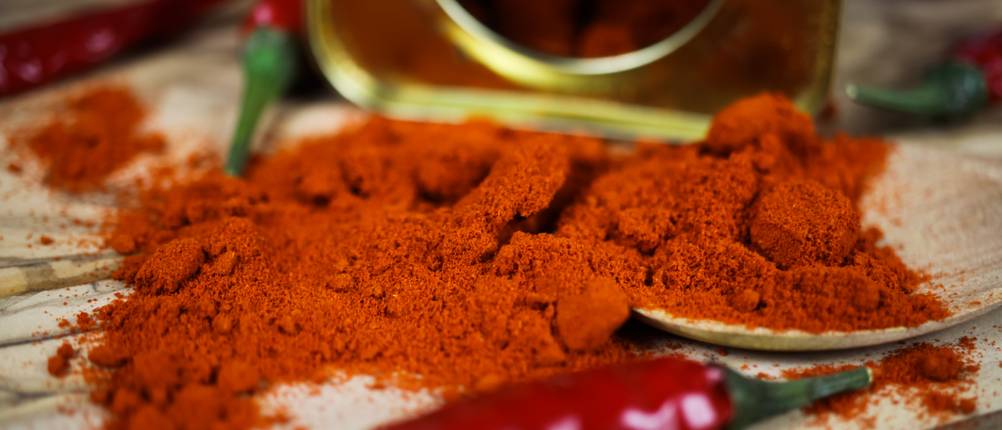 geräuchertes Paprikapulver neben einer Paprika-Schote