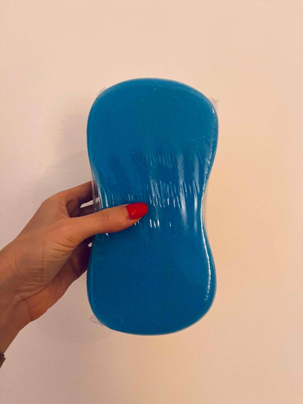 Im Test: Hand zeigt die blaue Seite eines verpackten Polierschwamms.