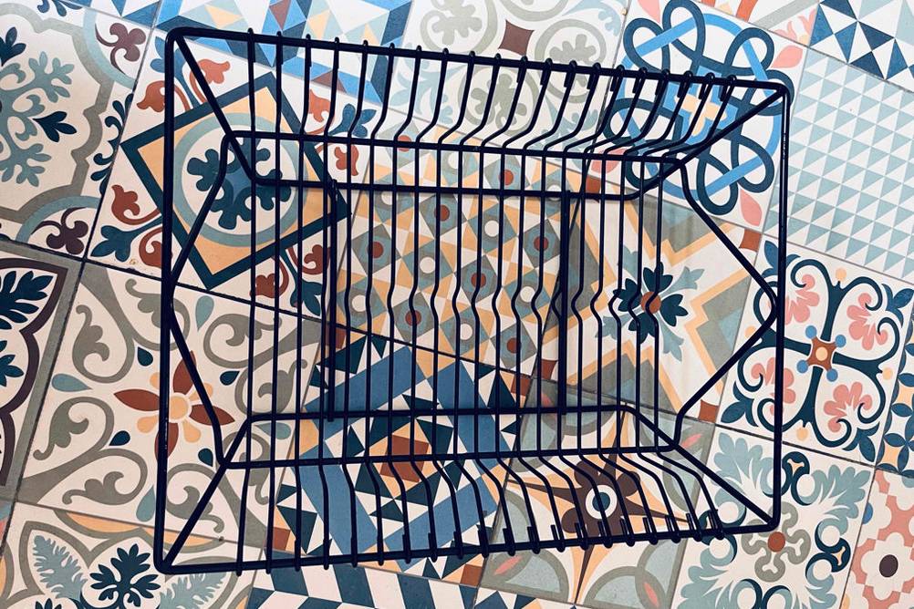 Getestetes Abtropfgestell für Geschirr befindet sich auf einem gemusterten Untergrund.