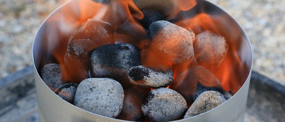 Grillanzünder steht brandsicher vor einem Hintergrund aus Stein.