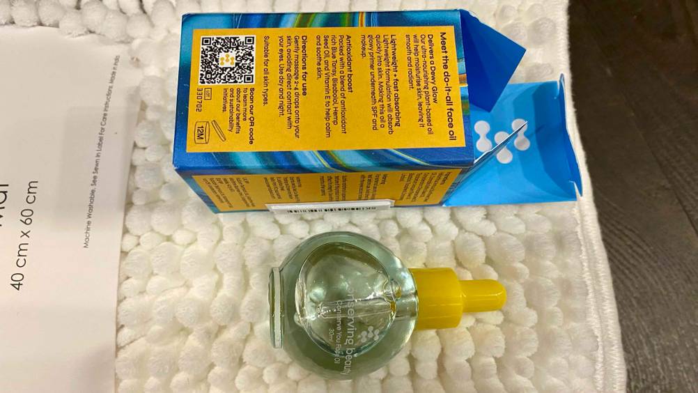 Gesichtsöl-Test: Ein Fläschchen liegt neben seiner umgedrehten Originalverpackung.