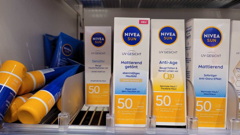Mehrere Packungen der getesteten getönten Sonnencreme in einem Verkaufsregal neben anderen Produkten.