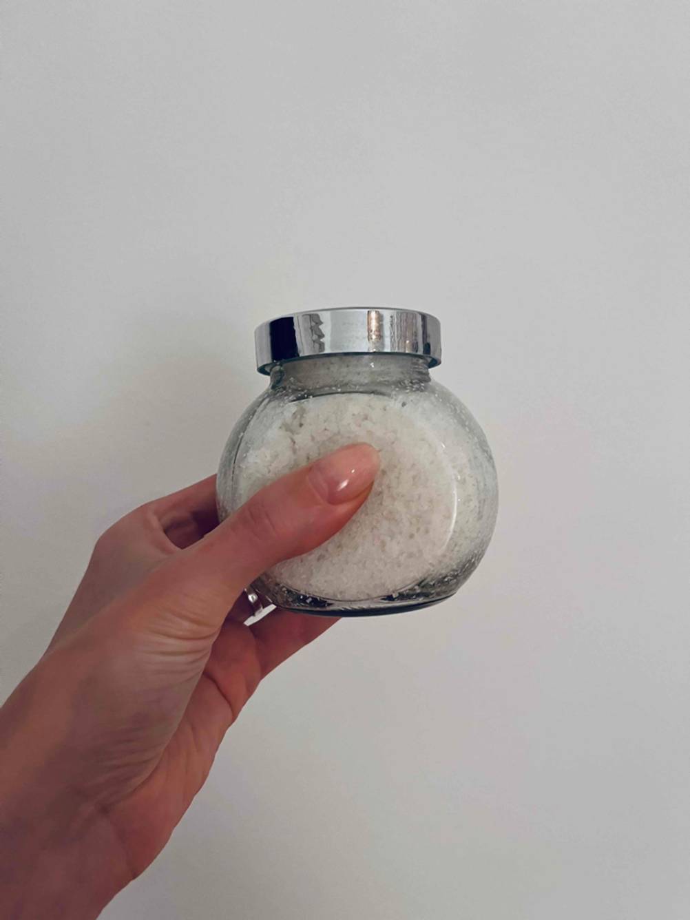 Im Test: Eine Hand hält ein Gewürzglas seitlich vor eine helle Wand.