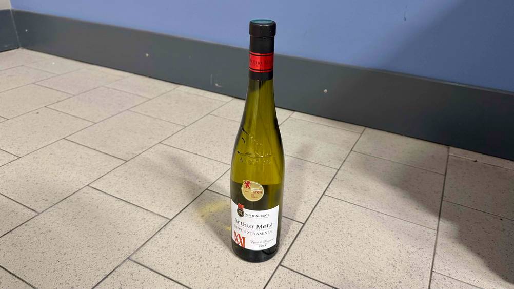 Vor einer blauen Wand steht der getestete Gewürztraminer.