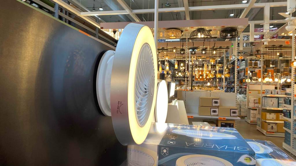 Seitenansicht eines getesteten LED-Deckenventilators, der in einem großen Verkaufsraum hängt.