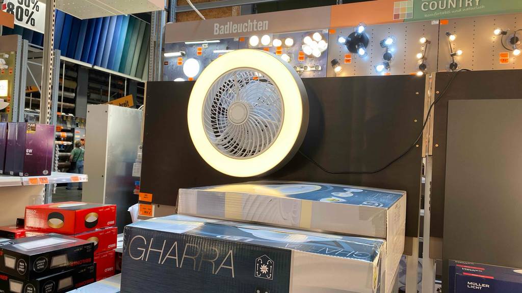 Ein LED-Deckenventilator hängt über der Originalverpackung an einer Wand zum Testen.