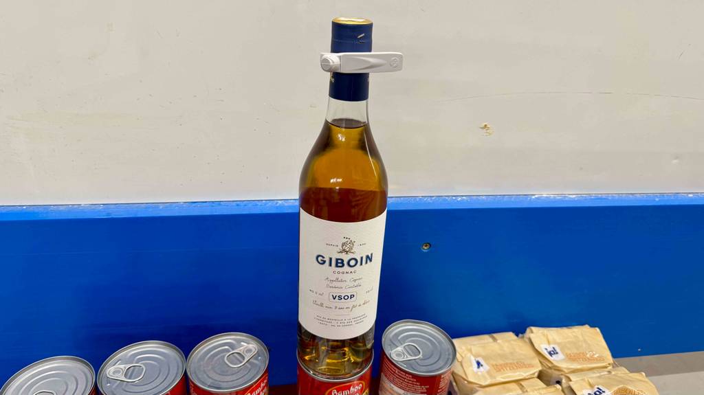 Getestet: Eine Flasche Cognac-VSOP steht auf einer Dose vor einer blau-weißen Wand.