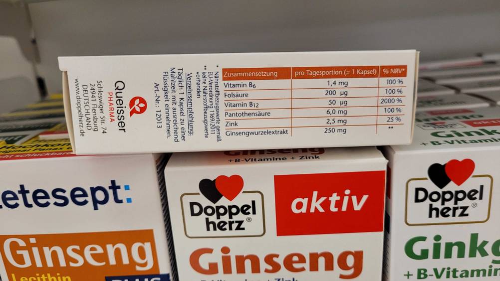 Nahaufnahme der Seite der Verpackung der getesteten Ginseng-Kapseln mit Angaben zur Zusammensetzung auf anderen Packungen liegend.