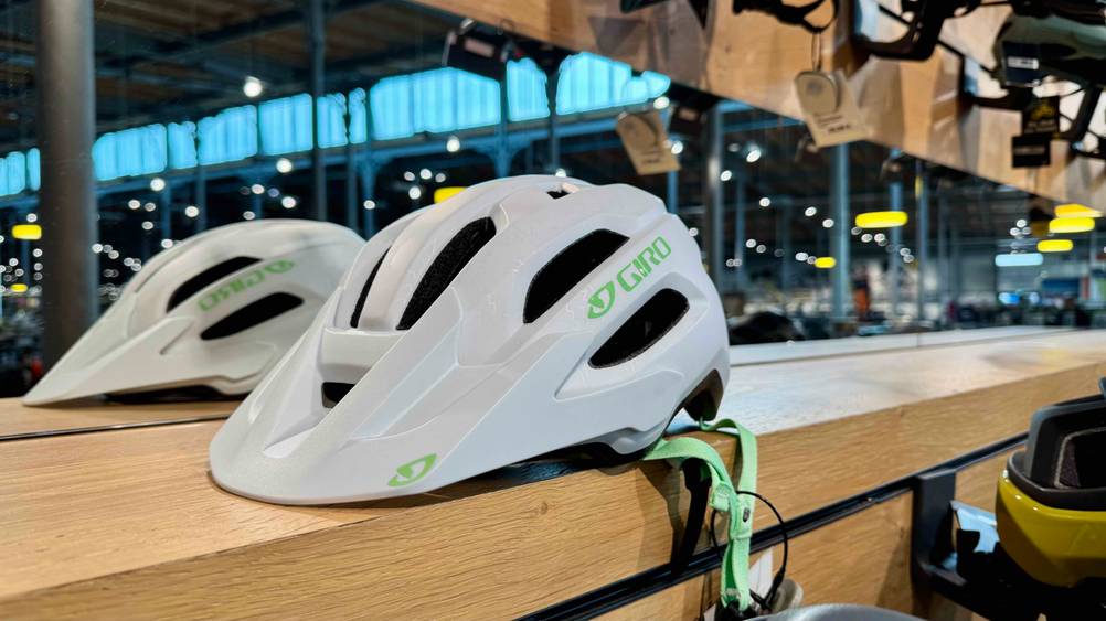 Der getestete Giro Fahrradhelm vor einem Spiegel auf einem Holzbrett.
