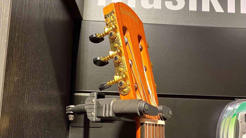 Der Kopf von einer getesteten Gitarre in einer Gitarrenhalterung in Nahaufnahme.