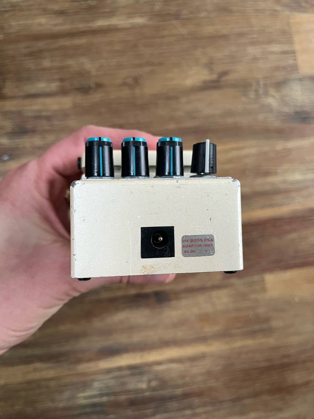 Eine Hand hält das Gitarren-Effektgerät im Test so, daß man die Kopfseite sieht.