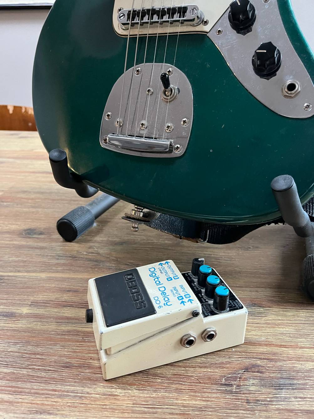 Das Gitarren-Effektgerät im Test von der Seite mit Anschlüssen vor einer Gitarre.