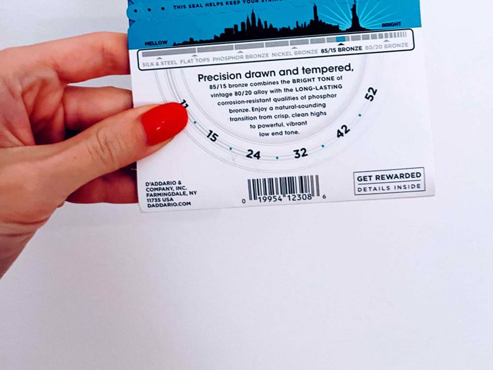 Gitarrensaiten-Test: Nahaufnahme der Rückseite der Verpackung von einer Hand gehalten.