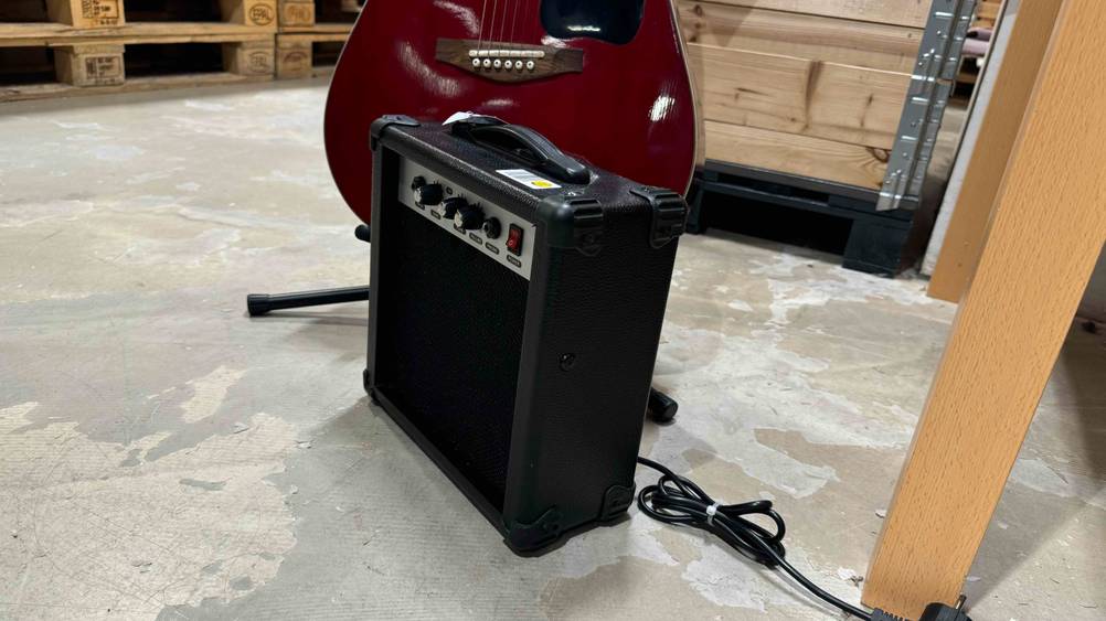 Getestet: Ein Gitarrenverstärker von der Seite vor einer Gitarre stehend.