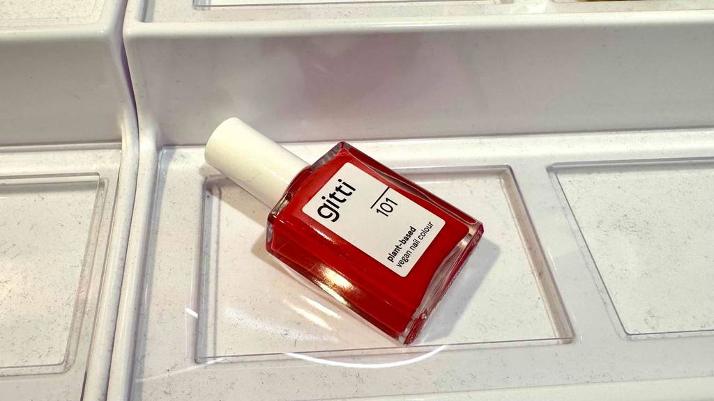 Im Test: veganer Nagellack in Rot liegt auf einer weißen Oberfläche.