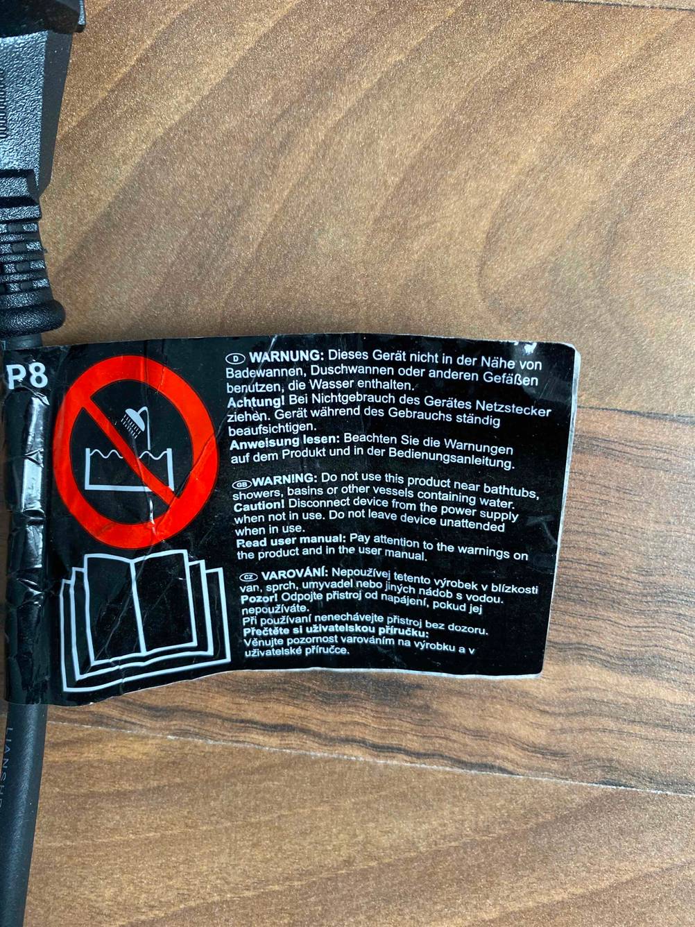 Nahaufnahme des Gefahrenlabels eines Glätteisen im Test.