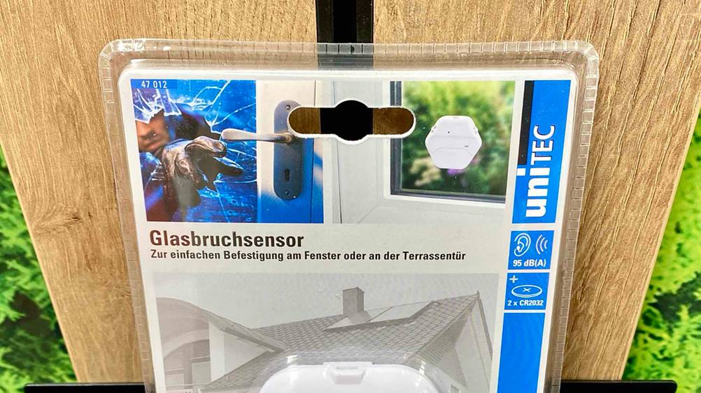 Nahaufnahme des Logos und der Artikelbezeichung eines Glasbruchmelders im Test.