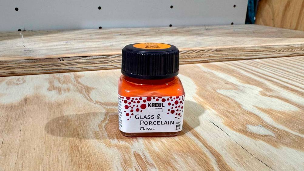 Glasfarbe getestet: Ein Fläschchen auf einer Holzfläche.