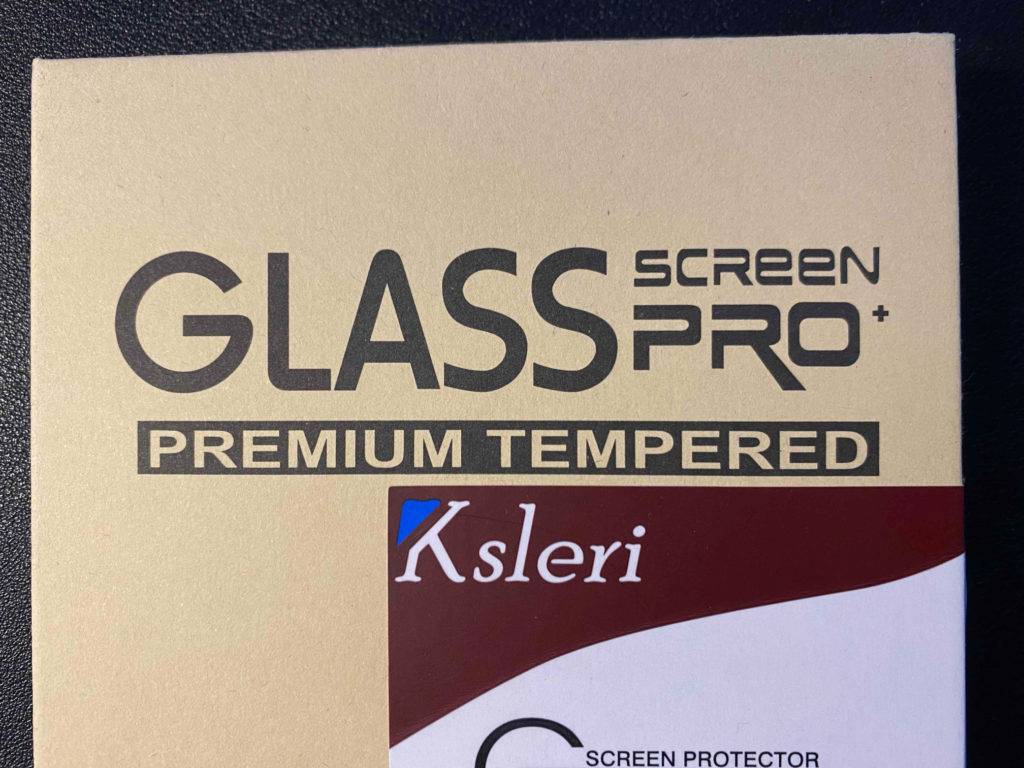 Detailansicht der beigefarbenen Verpackung eines iPhone 12 Pro Panzerglases im Test, mit der Aufschrift 