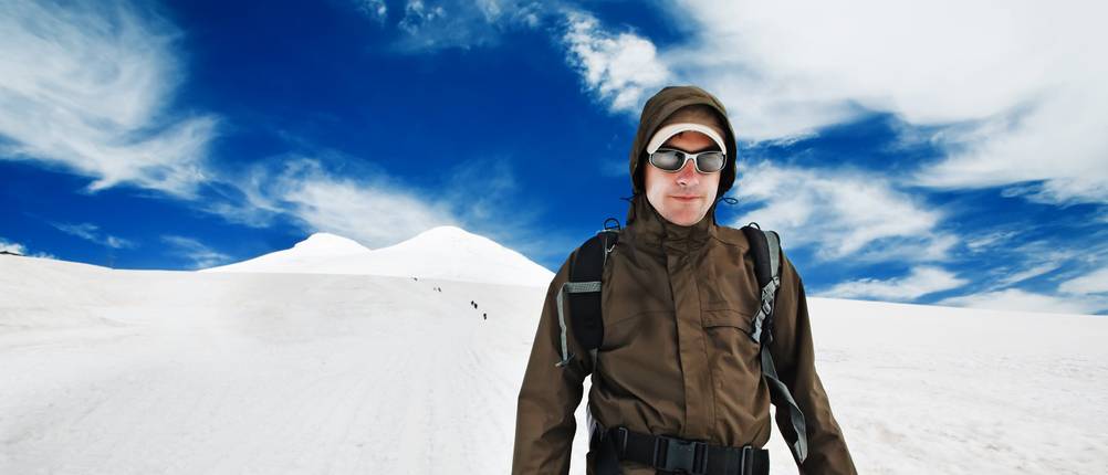 Gletscherbrille im Test: Mann, der auf einem schneebedeckten Berg eine Gletscherbrille trägt