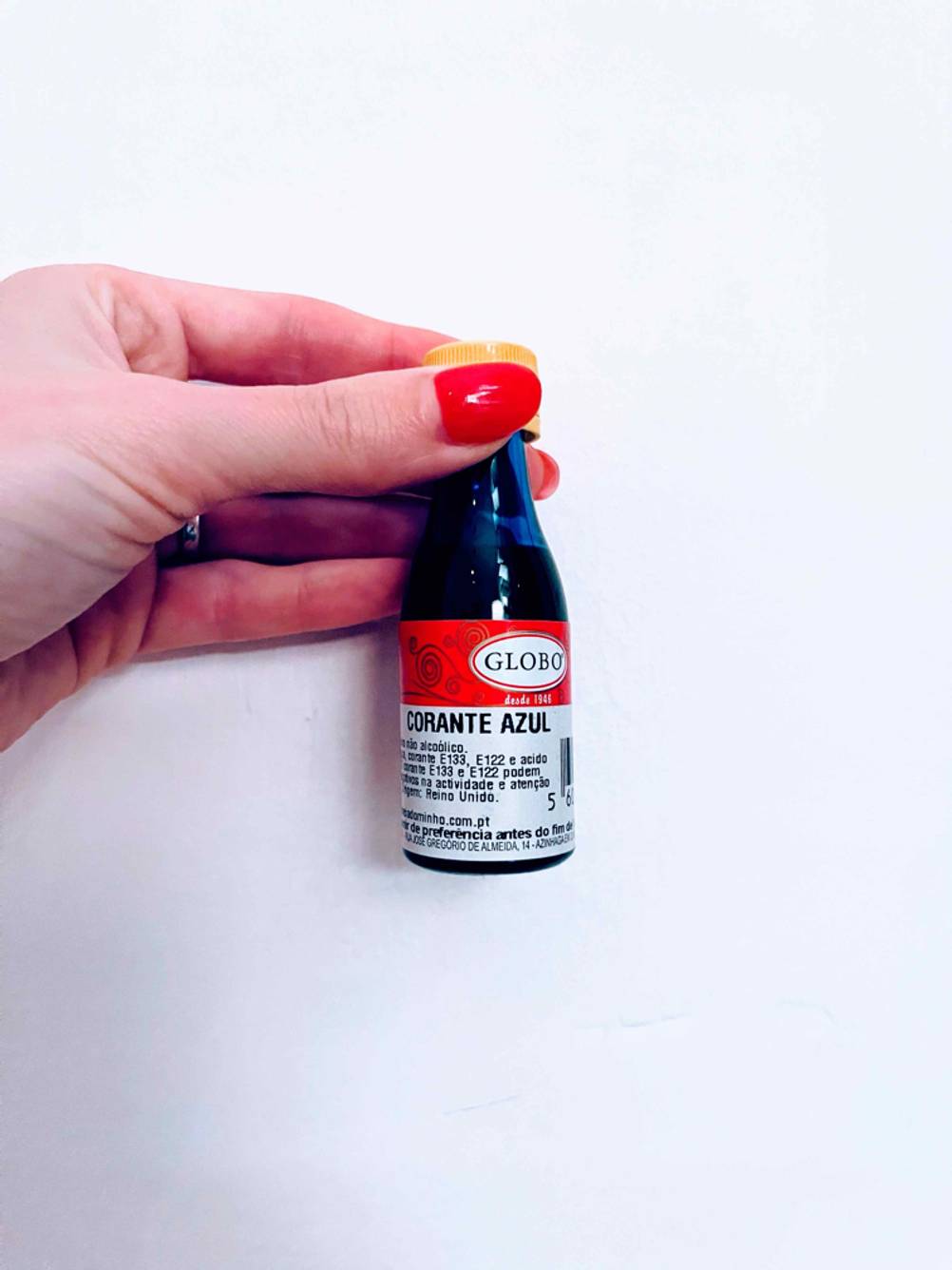 Detailaufnahme des Labels einer Flasche Lebensmittelfarbe im Test, die von einer Hand gehalten wird.