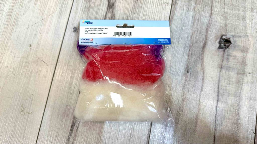 Die Filzwolle im Test liegt innerhalb der Verpackung auf einer Holzfläche.