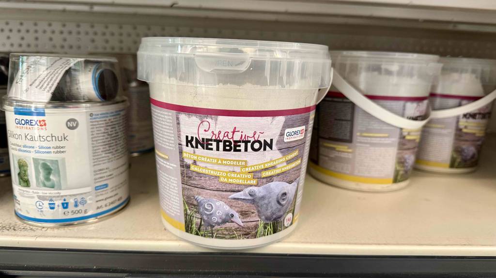 Knetbeton im Test: Mehrere Eimer stehen in einem Regal.
