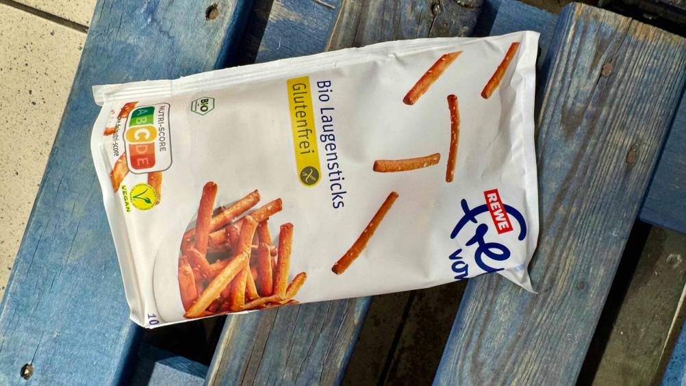 Eine Packung der getesteten glutenfreien Snacks von oben horizontal auf einer Holzpalette.