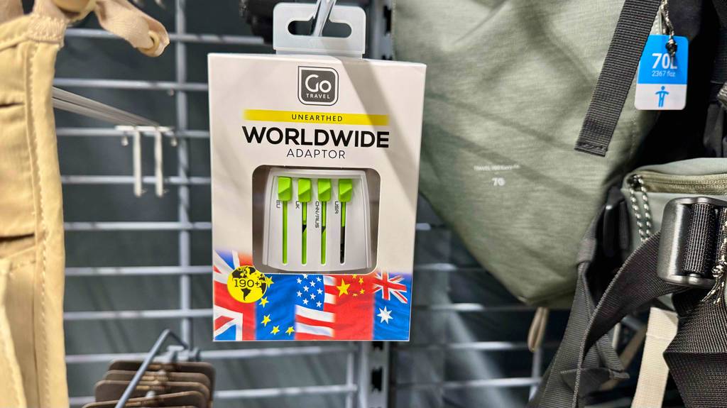 Die Verpackung mit dem getesteten weltweiten Reiseadapters hängt an einem Verkaufsregal.