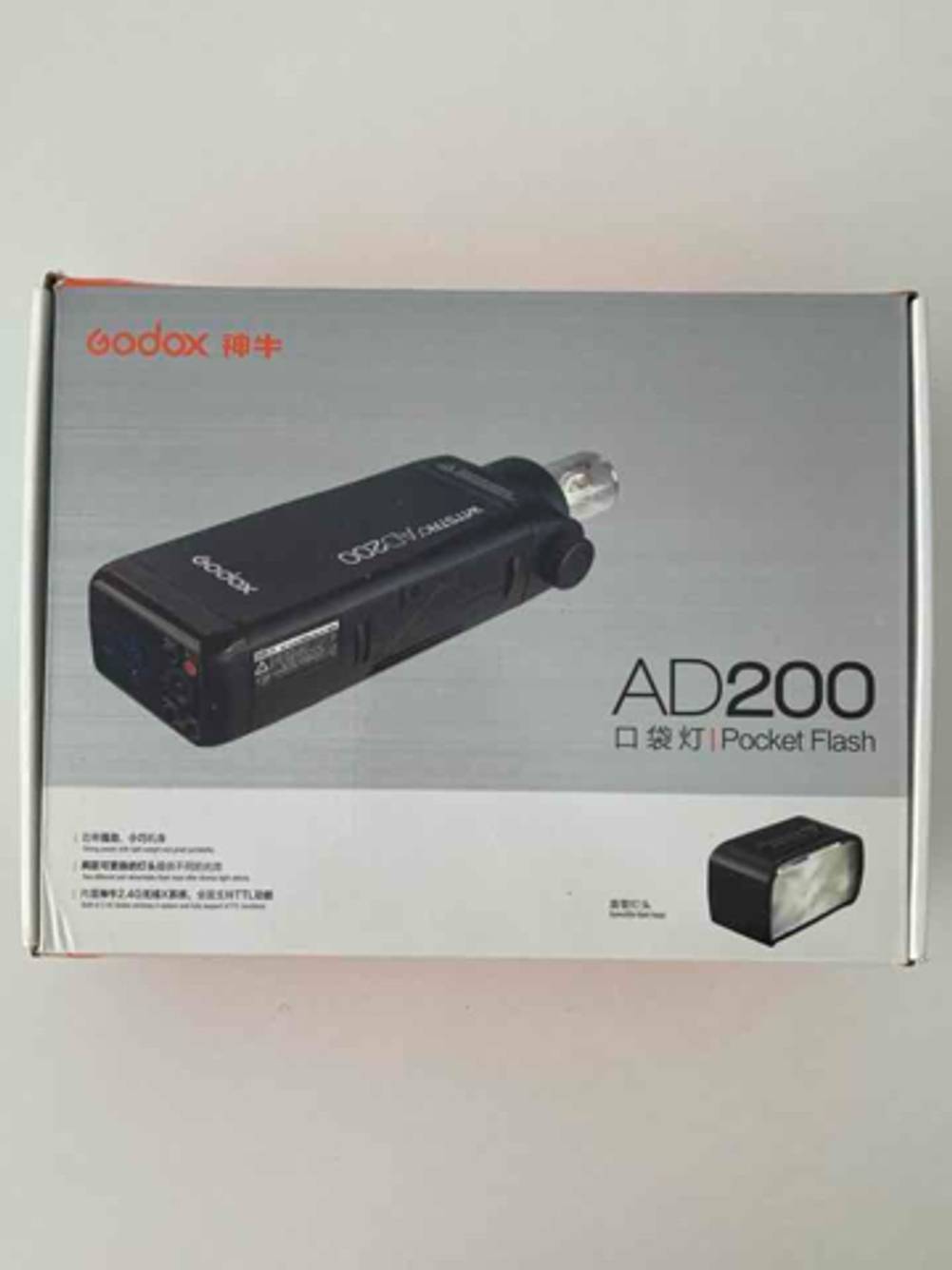 Eine Verpackung mit dem getesteten Godox-Blitzgerät liegt auf einer weißen Oberfläche.