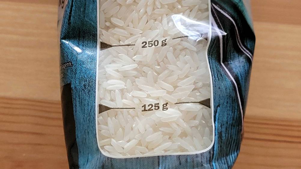 Im Test: Nahaufnahme des transparenten Fensters einer Packung Jasmin-Reises mit Skala.