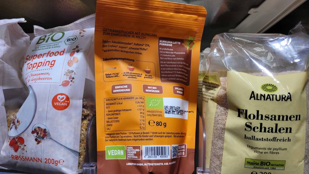 In einem Verkaufsregal steht eine Packung des Goldene-Milch-Pulvers mit der Rückseite nach vorne.