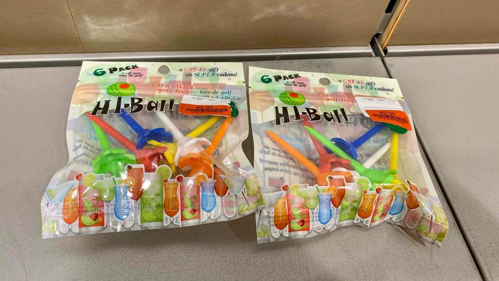 Golf-Tees getestet: Zwei Packungen liegen nebeneinander auf einer grauen Fläche.