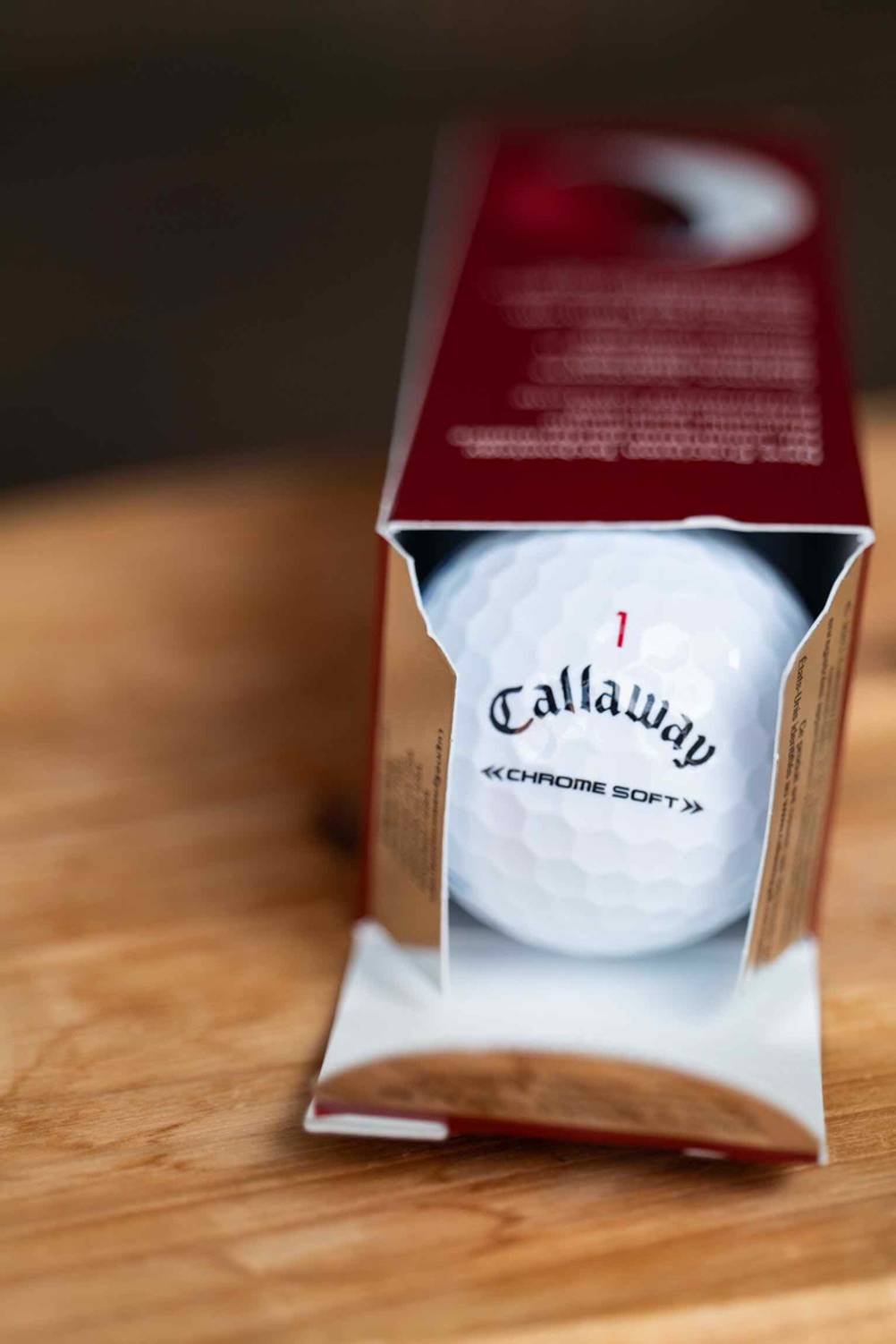 Golfball getestet: Eine geöffnete Packung aus der ein Golfball rollt.