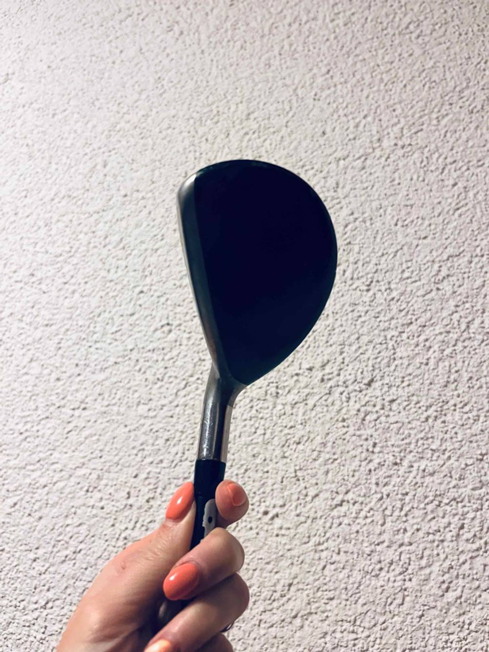 Die Unterseite eines Golfschlägers im Test von einer Hand gehalten.