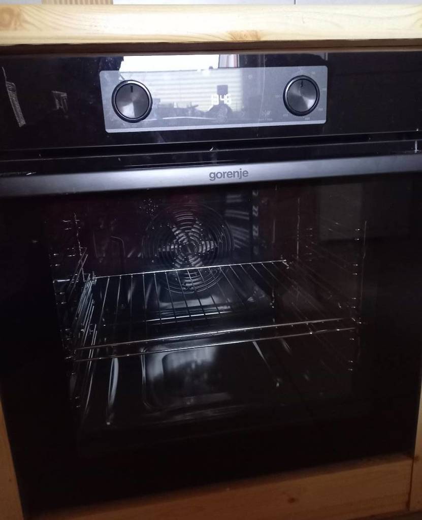 Nahaufnahme von einem getesteten Induktionsherd von Gorenje inklusive Backofen in Küchenzeile aus Holz.