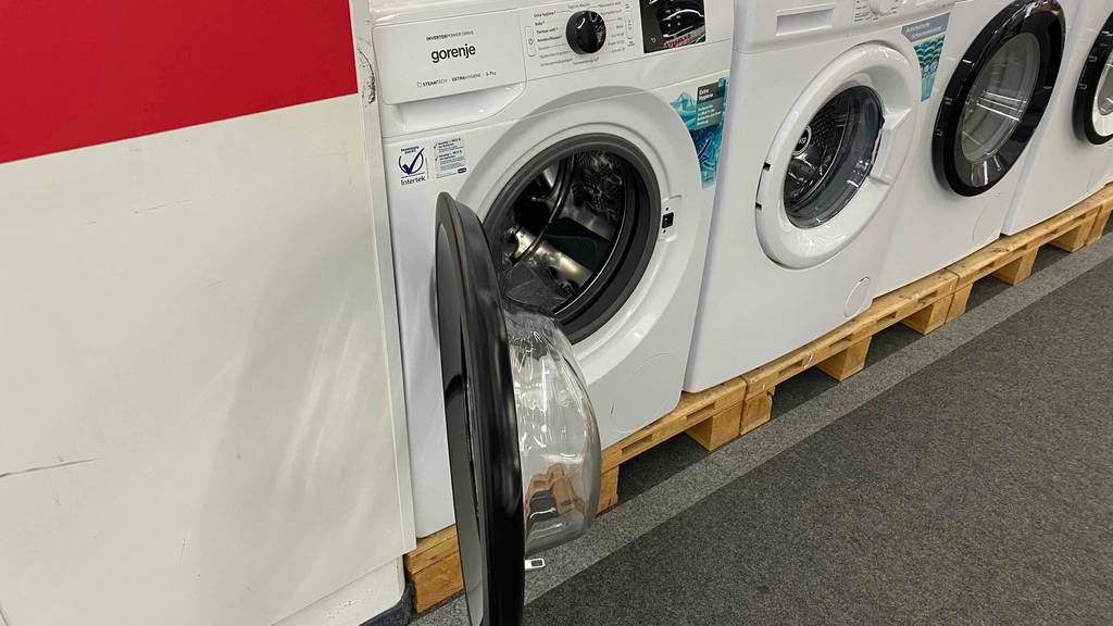 Gorenje Waschmaschine im Test: ein Gerät steht mit offener Tür neben anderen Marken auf Paletten.