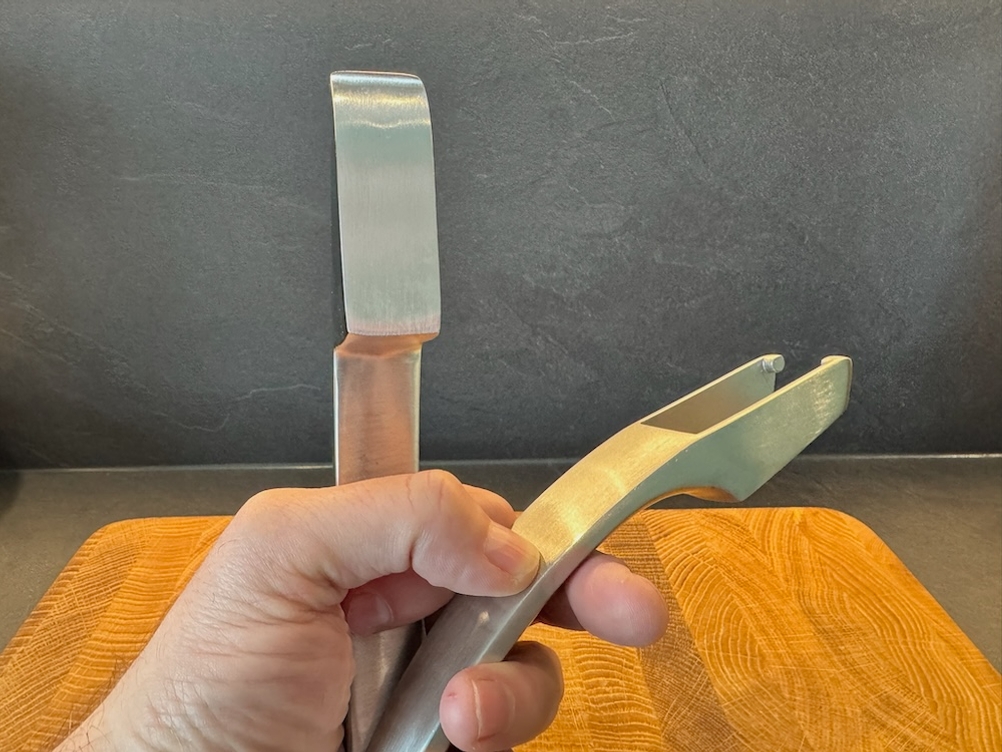 Eine Hand hält die zwei Einzelteile der Gourmet Easy Knoblauchpresse.