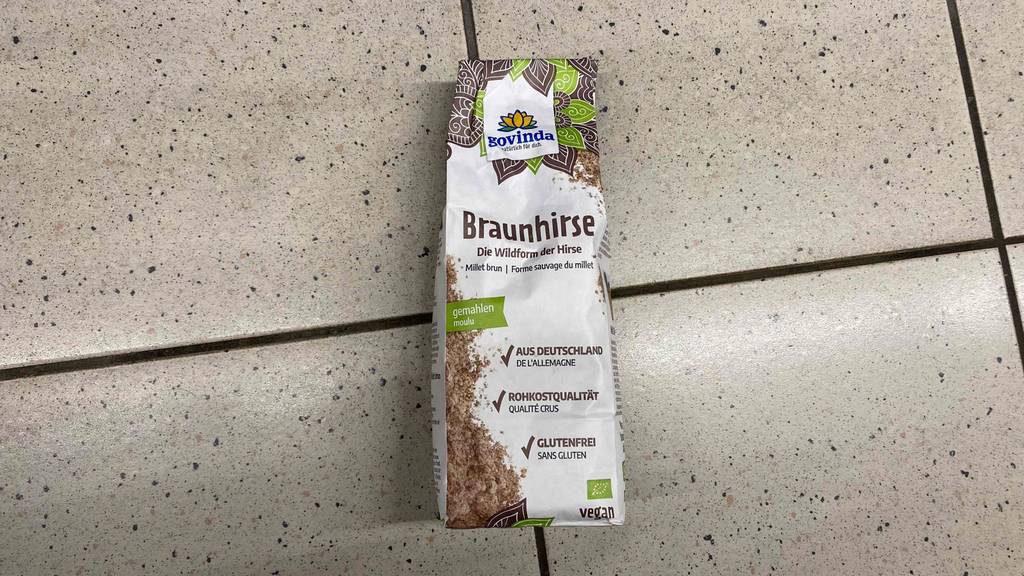 Eine Verpackung mit gemahlener, getesteter Braunhirse von Govinda liegt auf einem Boden.