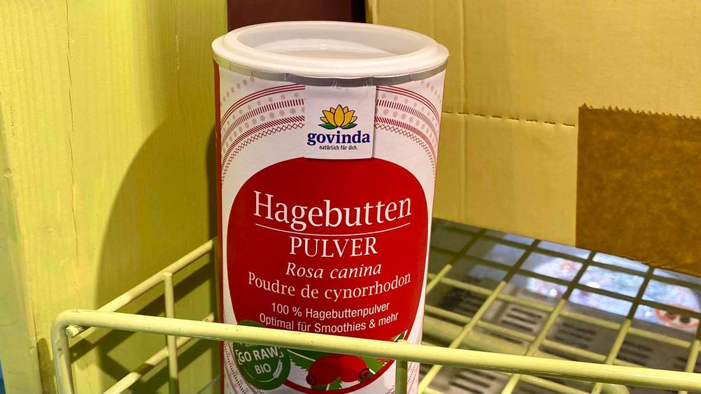 Eine Dose Hagebuttenpulver der Marke govinda steht zum testen in einem Gitterregal.