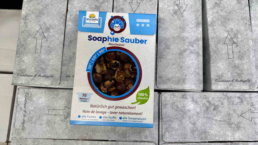 Blick von oben auf eine Packung getestete Waschnüsse, die auf mehreren Kartons liegt.