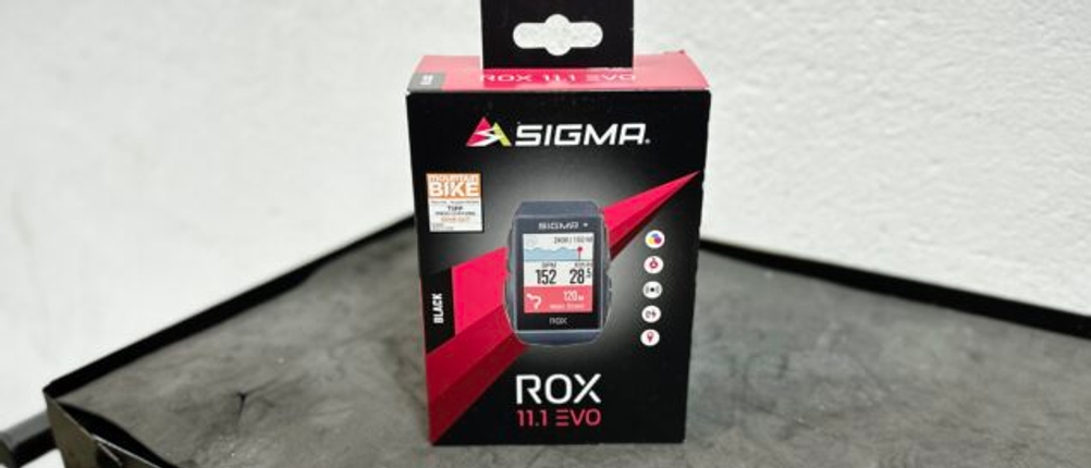 Die Originalverpackung des Sigma ROX 11.1 EVO Fahrradcomputers steht auf einer dunklen Oberfläche. Das Design zeigt das Gerät mit einer digitalen Anzeige auf dem Display.