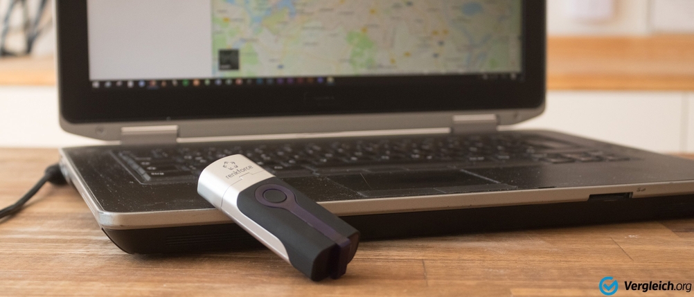 GPS-Fahrradtracker liegt vor einem Laptop, der Google-Maps geöffnet hat.