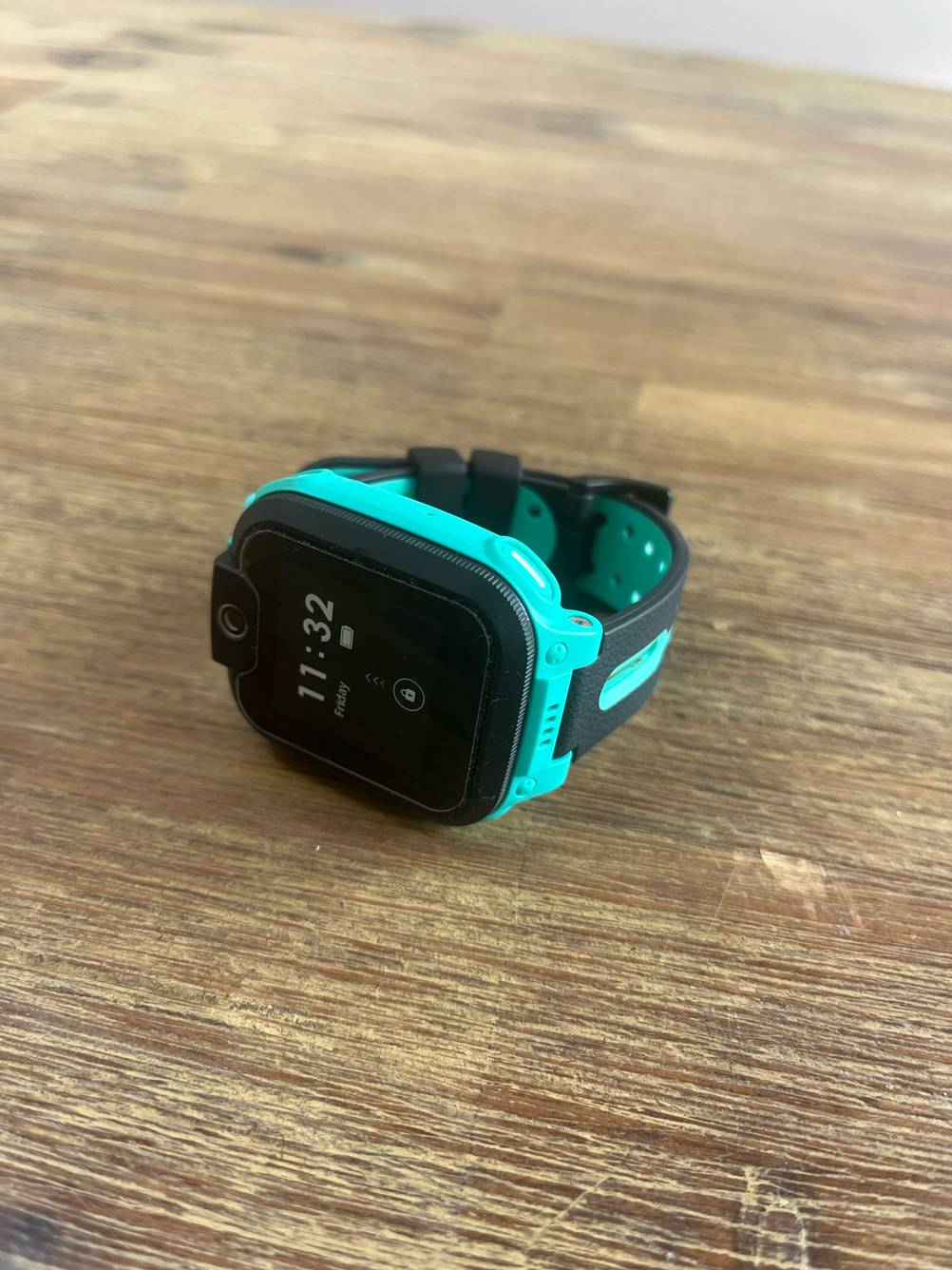 Im Test: Eine GPS-Uhr von schräg vorne auf einem Holztisch liegend.