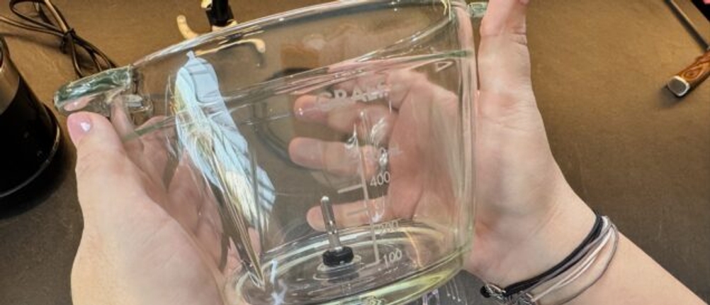 Zwei Hände hält den Behälter des Graef CH 502 fest.